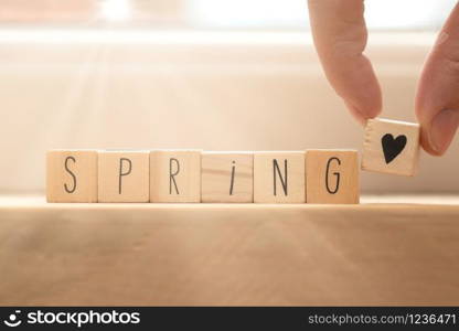 Wooden cubes with heart symbol and the word spring, social media concept spring background beauty. Wooden cubes with heart symbol and the word spring, social media concept spring background