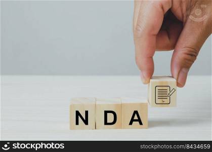 Wooden cubes with NDA Non disclosure Agreement icon symbol background and copy space.