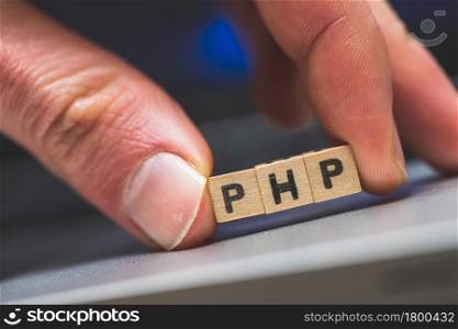 Wooden cubes with the letters ?PHP? are lying on a laptop