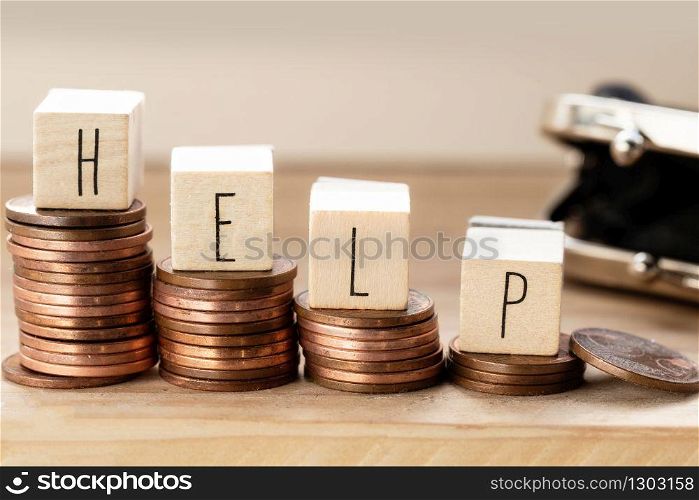 Wooden cubes with the word Help and pile of coins, money stairs, business concept background. Wooden cubes with the word Help and pile of coins, money stairs, business concept