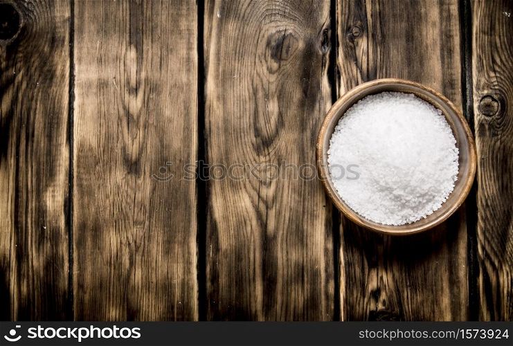 Wooden Cup with salt . On a wooden background. . Wooden Cup with salt . On wooden background.