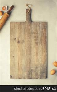 Wooden cutting board and baking imgredients. Top view, copyspace