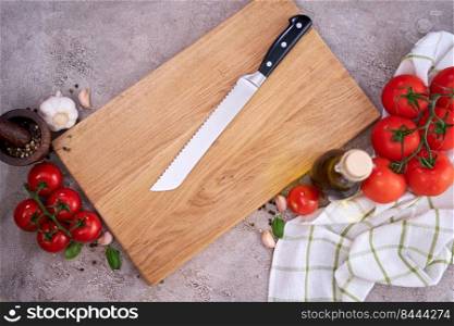 wooden cutting board and Steel kitchen bread knife on grey kitchen tab≤.. wooden cutting board and Steel kitchen bread knife on grey kitchen tab≤