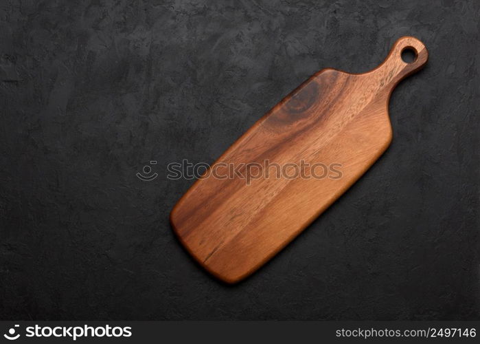 Wooden cutting board, clean and new, on dark rustic background