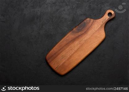 Wooden cutting board, clean and new, on dark rustic background