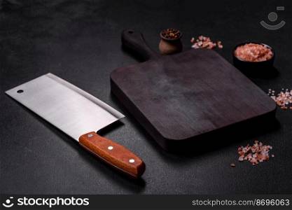 Wooden cutting board with kitchen appliances on a black concrete background. Cooking at home. Wooden cutting board with kitchen appliances on a black concrete background