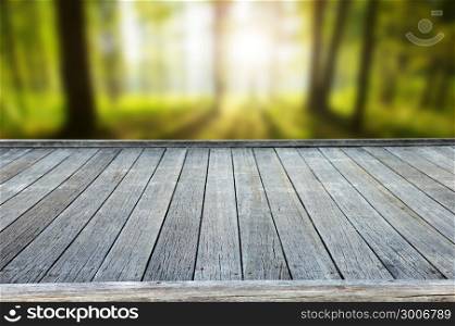 wooden deck table with forest background