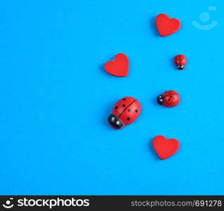 wooden decor red heart and ladybug on a blue background, close up