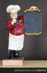 wooden decorative cook holding poster, dressed in typical chef clothing