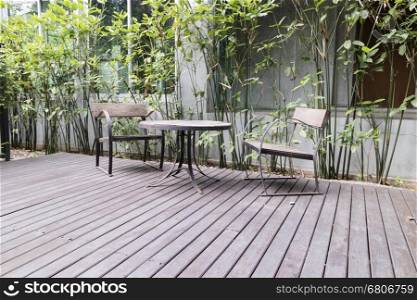 wooden desk and chair on patio beside garden