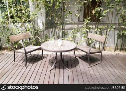 wooden desk and chair on patio beside garden