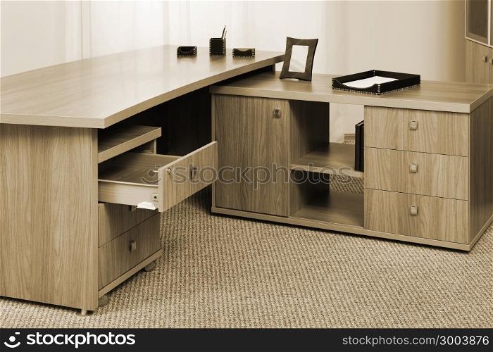 wooden desk with an open drawer in the office