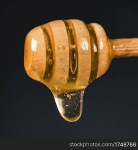 Wooden Dipper with Flowing Honey, close up  . Wooden Dipper with Flowing Honey 