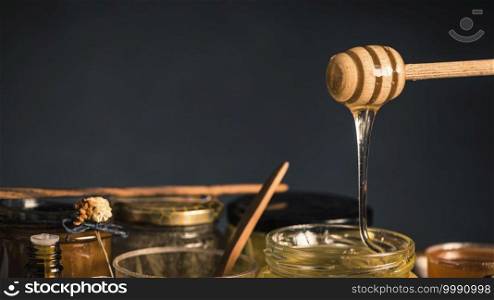 Wooden dipper with flowing honey, copy space. Wooden Dipper with Flowing Honey 