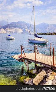 Wooden dock and sailing boats at the coastline