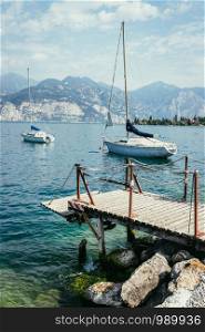 Wooden dock and sailing boats at the coastline