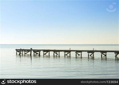 Wooden Dock As Minimalism Background. Wooden dock over calm ocean water as minimalism background