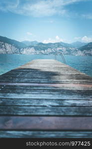 Wooden dock pier, mountains and lake. Copy space for text.