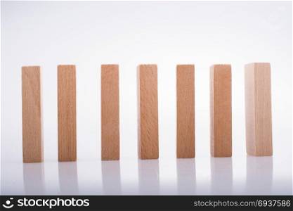 Wooden Domino Blocks in a line on a white background