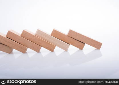 Wooden Domino Blocks in a line on a white background