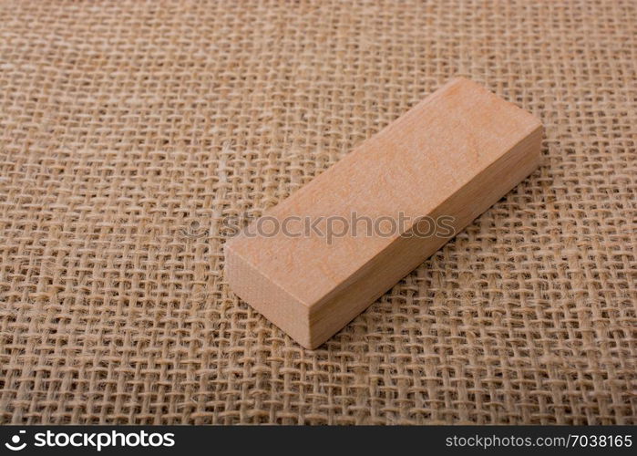 Wooden domino on a linen canvas background