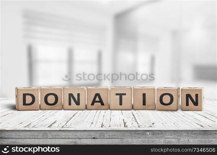 Wooden donation sign on a worn desk in a bright room with lights