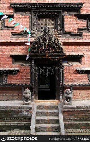 Wooden door amd brick wall of temple in Bhaktapur, Nepal