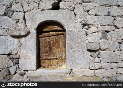 Wooden door and stone wall of old house in Cappadocia, Turkey