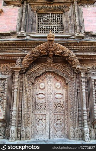 Wooden door and window on the wall of palace in Patan, Nepal