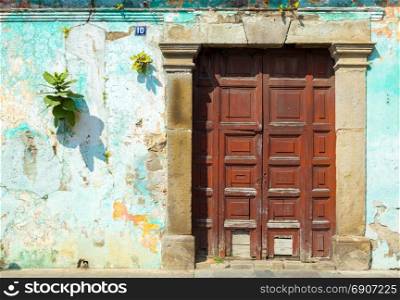 Wooden door in rustic blue spanish colonial wall, Antigua, Guatemala, Central America