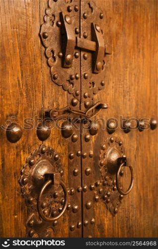 Wooden doors with ornate metal knobs and locks.