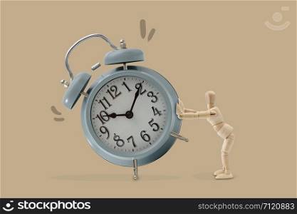 Wooden dummy push a big clock, Isolated on brown background, Idea and concept of time picture.