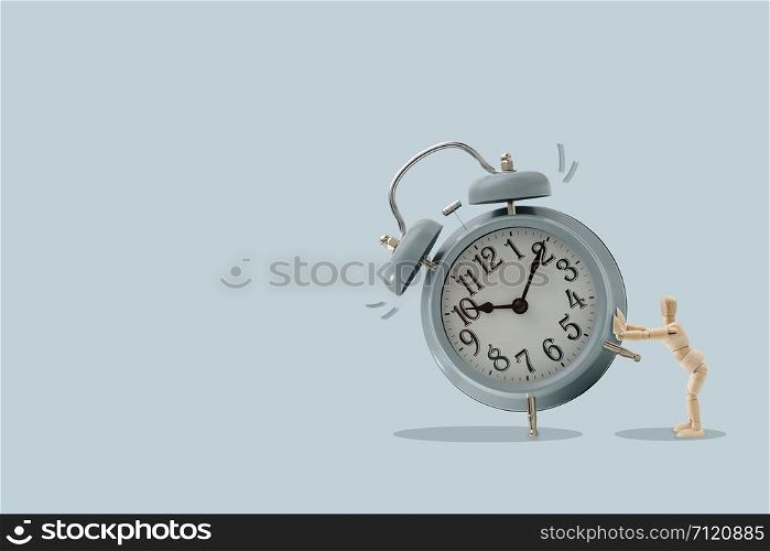 Wooden dummy push a big clock, Isolated on brown background, Idea and concept of time picture with copy space to write.