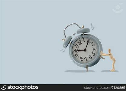 Wooden dummy push a big clock, Isolated on brown background, Idea and concept of time picture with copy space to write.