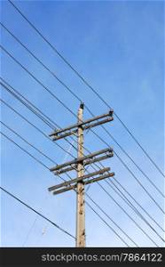 Wooden electrical transmission pole and power lines against sky.