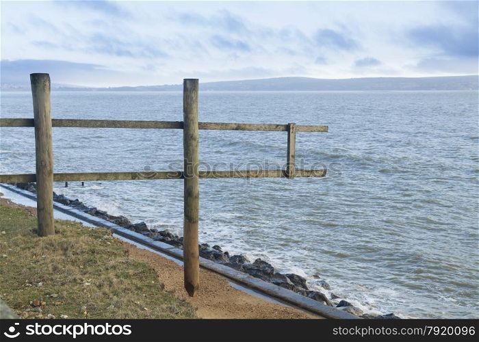 Wooden fence ending in mid-air over sea. After the February 14 2014 Valentine?s Day Storm, Milford on Sea, Hampshire, England, UK
