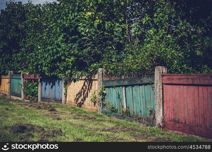 Wooden fence in various colors in a yard
