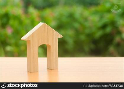 Wooden figure of a house with a large doorway on nature background. Home, Affordable housing, residential building. concept of buying and selling real estate, rent, investment and construction.