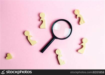 Wooden figures of lonely people around a magnifying glass. Search for love and creation of strong love relationships. Dating and flirt, search for a love partner. finding a couple on Valentine’s Day.
