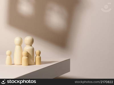 wooden figurines of a family on a background of shadow in the form of a house. Beige background. Home dreams, mortgage