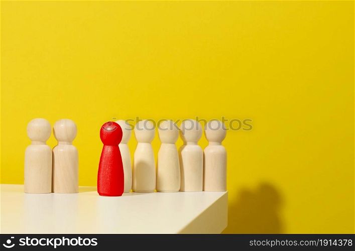 wooden figurines of men and one red on a blue background. Leader and recruiting concept. Toxic personality in the team