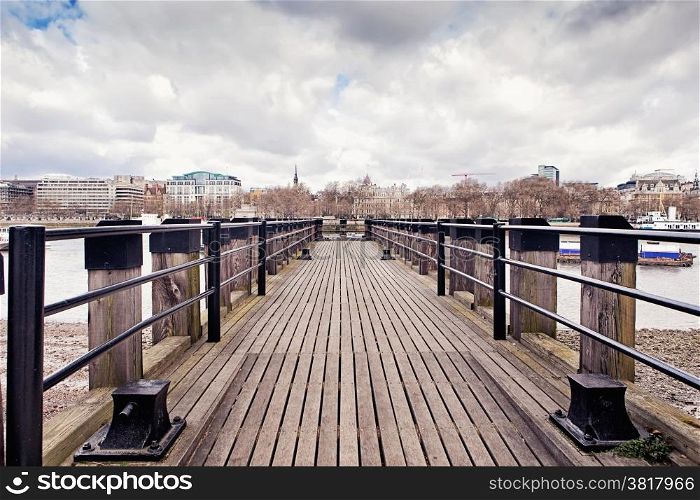 Wooden fishing pier on the south bank of the river Thames in London