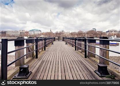 Wooden fishing pier on the south bank of the river Thames in London