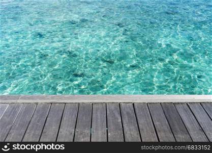 Wooden floor with clear sea water, maldives