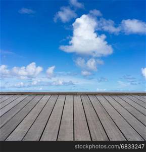 wooden floor with cloudy blue sky background