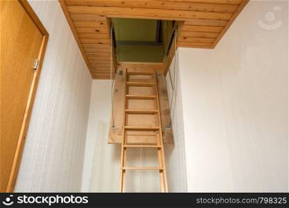 Wooden folding ladder to the attic, old empty house close-up. Wooden folding ladder to the attic, old empty house