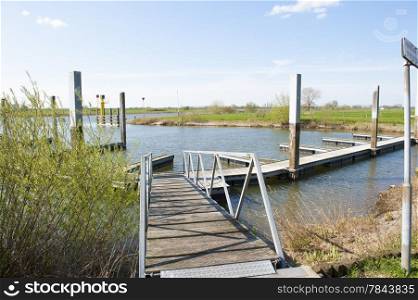 Wooden footpath of landing place at riverside in a rural and scenery landscape