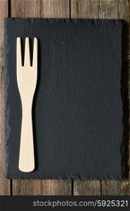 Wooden fork on slate background