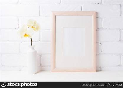 Wooden frame mockup with soft yellow orchid in vase. Empty frame mock up for presentation design. Template framing for modern art.. Wooden frame mockup with soft yellow orchid in vase