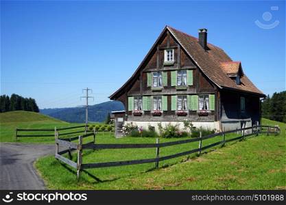 Wooden fsarm house and green pasture in Switzerland